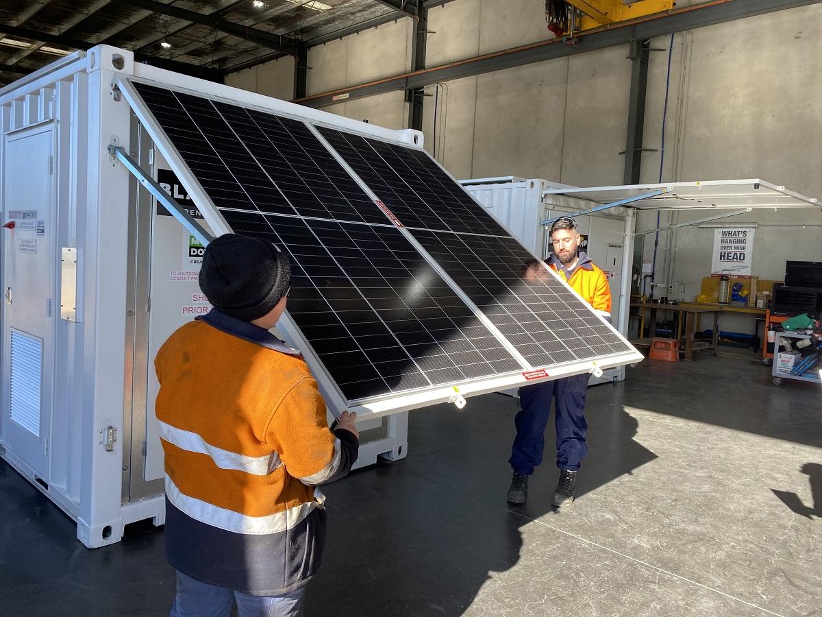 Image of people deploying Solarator roof panel